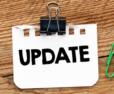 Küçük bir kağıt parçası ve ahşap bir masa üzerinde güncel sözcük.