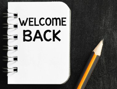 Ofis defterindeki siyah arka plandaki sözlere hoş geldin. İş kavramı.