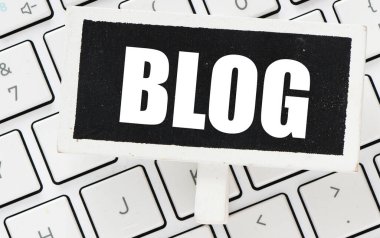 Arka planda küçük bir tebeşir tahtası ve bilgisayar klavyesindeki BLOG kelimesi.