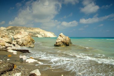 Kıbrıs 'taki ünlü Afrodit Kayası (Petra tou Romiou), turkuvaz suları, engebeli uçurumları ve açık mavi gökyüzü ile efsanevi bir kıyı simgesi. Popüler Akdeniz seyahat noktası ve ikonik