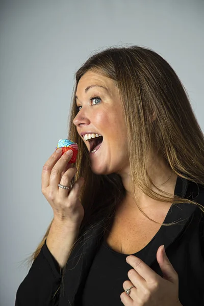 Isolated Forty Year Old Woman Eating Small Cupcake — Stock Photo, Image