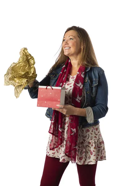 四十来岁的女人 穿着休闲装 开著一个大大的笑着的礼品袋 图库图片