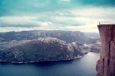 Ümitsiz adam Lysefjord 'un üzerindeki ünlü Preikestolen Minpit Rock' ta duruyor.