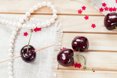 Tahta arka planda dört kiraz.