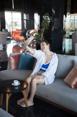 Kız lobide selfie çekiyor.