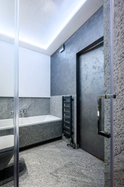 Mermer kaplamalı şık bir dairede modern küçük banyo.