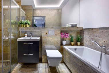 Mermer kaplamalı şık bir dairede modern küçük banyo.