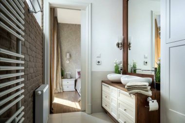 Ahşap kaplamalı şık bir dairede modern küçük banyo.