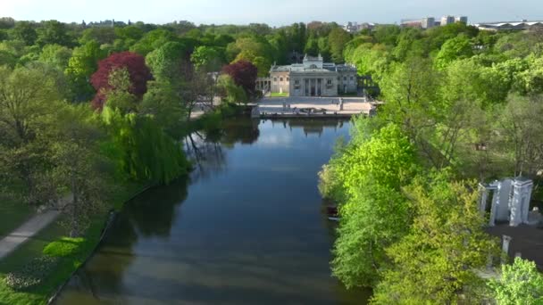 晴れた午後にポーランドのワルシャワにあるLazienki公園の空中ビュー 島の王宮 バス宮殿として知られている 湖を2つの部分 小さな北部の湖と大きな南部の1つに分割します — ストック動画