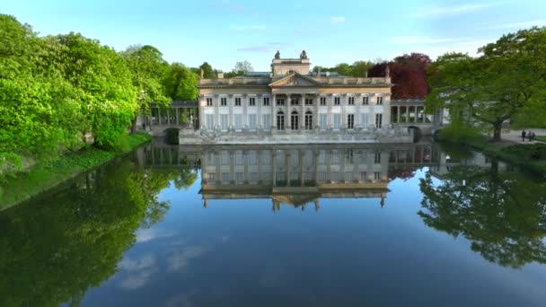 晴れた午後にポーランドのワルシャワにあるLazienki公園の空中ビュー 島の王宮 バス宮殿として知られている 湖を2つの部分 小さな北部の湖と大きな南部の1つに分割します — ストック動画