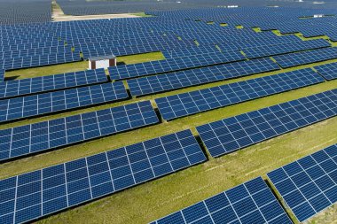 Çiftlikteki güneş panellerinin havadan görüntüsü. Yeşil alana sahip enerji santrali, Polonya, Avrupa 'da yenilenebilir enerji kaynağı. Sanayide elektrik enerjisi için eko teknoloji.