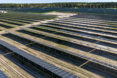 Çiftlikteki güneş panellerinin havadan görüntüsü. Yeşil alana sahip enerji santrali, Polonya, Avrupa 'da yenilenebilir enerji kaynağı. Sanayide elektrik enerjisi için eko teknoloji.