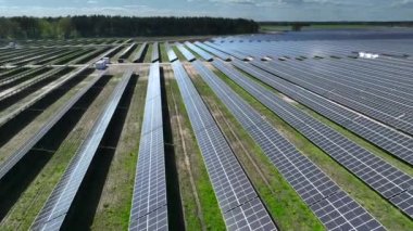 Polonya, Avrupa 'daki çiftlikteki güneş panellerinin hava görüntüsü. Yeşil alana sahip enerji santrali, Polonya, Avrupa 'da yenilenebilir enerji kaynağı. Sanayide elektrik enerjisi için eko teknoloji.