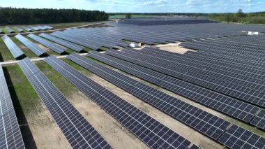 Polonya, Avrupa 'daki çiftlikteki güneş panellerinin hava görüntüsü. Yeşil alana sahip enerji santrali, Polonya, Avrupa 'da yenilenebilir enerji kaynağı. Sanayide elektrik enerjisi için eko teknoloji.