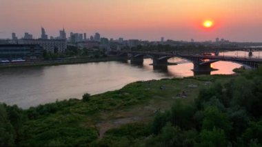 Günbatımında Vistula Nehri ve Poniatowski Köprüsü üzerindeki Varşova şehri manzarası. 