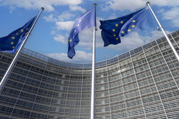Европейские флаги перед штаб-квартирой Европейской комиссии в Брюсселе в летний день

