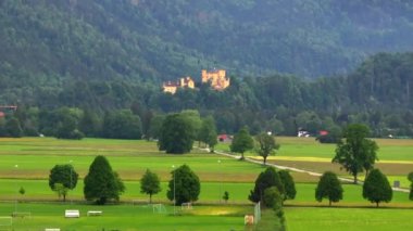 Neuschwanstein şatosu yakınlarındaki Saint Coloman Kilisesi 'nin insansız hava aracı eşliğinde Almanya' nın Bavyera eyaletindeki Schwangau dağlarının arka planına karşı.