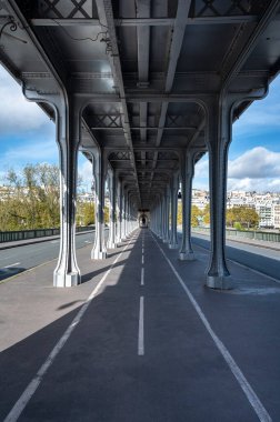 Bir Hakeim köprüsünün metal sütunları ve ayakları. İnsanlar Paris 'te köprünün altında yürür ve koşu yaparlar. Köprü en ünlü ve tarihi simgelerden biridir.