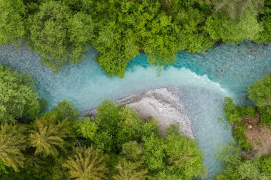 İsviçre 'deki Canton Graubunden Kantonu yakınlarında turkuaz suyu olan küçük nehrin insansız hava aracı görüntüsü..