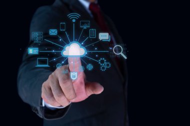 İş adamı eli, karanlık arka planda çeşitli simgelerle dijital bulut hologramına işaret ediyor. Bulut hesaplama ve depolama sunucu kavramı.