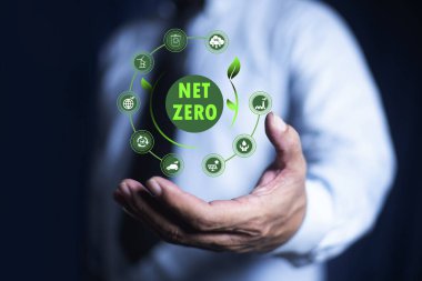 Sıfır ağ emisyonu, temiz teknoloji, yenilenebilir enerji konsepti. NetZero simgesini elinde tutan bir iş adamı. Ağ sıfır sera gazı emisyonları hedefi, iklim tarafsız uzun strateji