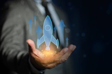 Koyu arkaplanda holografik roket tutan bir adam. Girişim kavramı, teknolojik yenilik ve iş buluşu