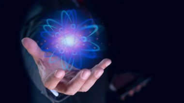 İşadamı yaratıcı atomu tutuyor. Nükleer füzyon konsepti, sonsuz enerji, ucuz elektrik, gelecekteki teknolojiler. Bilim ve gelecek kavramı
