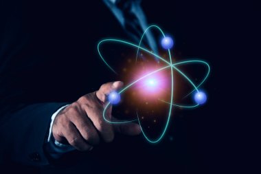 İşadamı yaratıcı atomu tutuyor. Nükleer füzyon konsepti, sonsuz enerji, ucuz elektrik, gelecekteki teknolojiler. Bilim ve gelecek kavramı