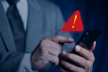 Cep telefonunda uyarı ve spam mesajı ikonu olan iş adamları. Sistem hacklenmiş kırmızı uyarı uyarısı.