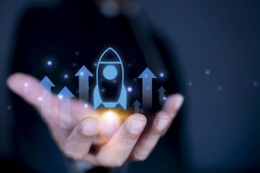 İş adamı sanal roket fırlatma yatırım büyümesini elinde tutarak, yeni iş ve yeniliği sembolize ediyor. Başarının gelişimi. Hedef başarı için liderlik iş stratejisi.