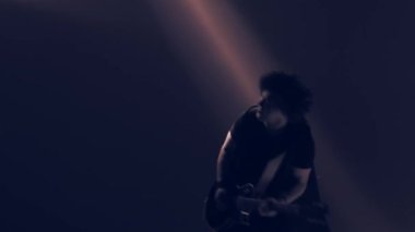 Genç bir adam elektro gitar çalıyor..