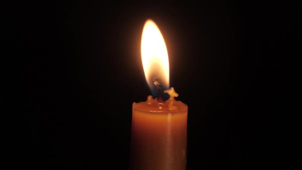 没有灯 没有电 一个蜡烛的火焰 黑色背景上柔和的黄色火焰 — 图库视频影像