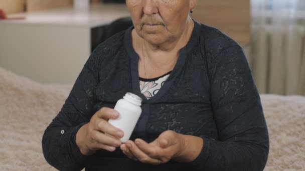 退休的女人 坐在房间里的老妇人 吃着医生开的药和药丸 — 图库视频影像