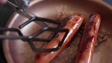 Kızarmış sosis. Tava pişiriyorum. Yakından ızgara sosis..