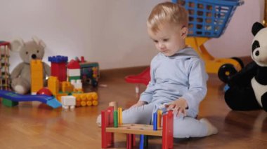 Bebekler anaokulunda bir kule inşa ederler. Çocuk renkli oyuncaklarla oynuyor.