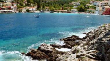 Deniz kıyısı. Dalgalar arka planda kayalara çarpıyor. Tatil köyü.