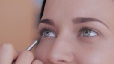 Makyaj sanatçısı, mankenlerin gözüne göz farı sürüyor..
