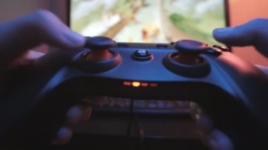 Delikanlı elinde joystickle bir video oyunu oynuyor. Joystick. Bir oyuncunun elleri, video oyunu oynayan genç bir oyuncu, bilgisayarında bir joystick kullanıyor. Oyun sırasında, ekranın önünde joystick.