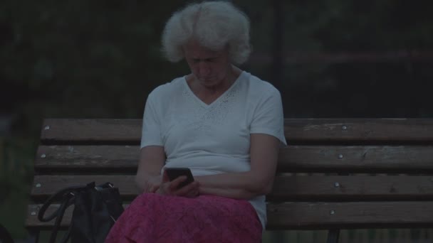 Telefondaki Kadın Bankta Oturan Emekli Kadın Elinde Telefon Olan Bir — Stok video