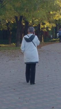 Sunny caddesinde konuşan ciddi bir emekli. Kapatın. Dışarıdaki kafeteryadan akıllı telefon arayan endişeli yaşlı kadın. Seçkin emekli kadın telefon konuşmasında sorun yaşıyor.