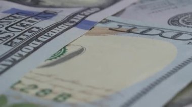 Masanın üzerinde yüzlerce Amerikan doları yavaşça dönüyor, yukarıdan görünüyor. Finansal başarı ve bolluk. - Evet. Yüksek kalite 4k görüntü