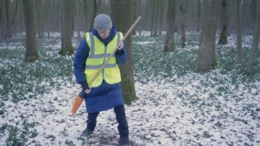 Bir gönüllü, karlı bir patikayı temizliyor. Çevresel koruma ve toplum ruhuna olan bağlılığını gösteriyor..