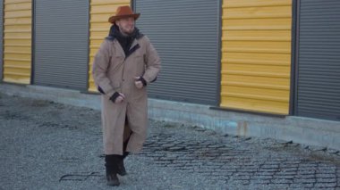Kendine güvenen, kendine özgü kovboy şapkası takan bir adam renkli bir arka plana cesur ve çarpıcı bir poz veriyor.