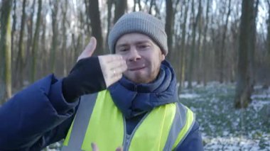 Güzel bir karlı ormanda parlak yansıtıcı yelek giyen bir birey kış boyunca doğayla derin bir ilişki içindedir.