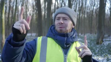 Güzel bir karlı ormanda parlak yansıtıcı yelek giyen bir birey kış boyunca doğayla derin bir ilişki içindedir.