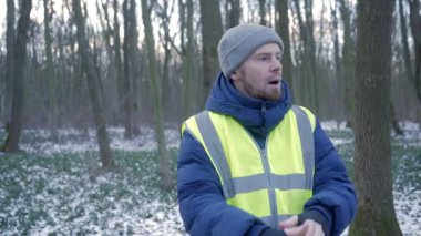 Güzel bir karlı ormanda parlak yansıtıcı yelek giyen bir birey kış boyunca doğayla derin bir ilişki içindedir.