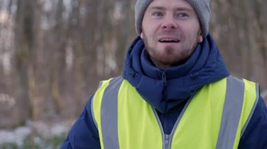 Güzel bir karlı ormanda parlak yansıtıcı yelek giyen bir birey kış boyunca doğayla derin bir ilişki içindedir.