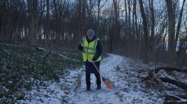 Güzel bir karlı ormanda parlak yansıtıcı yelek giyen bir birey kış boyunca doğayla derin bir ilişki içindedir.