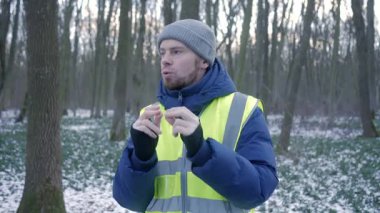 Güzel bir karlı ormanda parlak yansıtıcı yelek giyen bir birey kış boyunca doğayla derin bir ilişki içindedir.