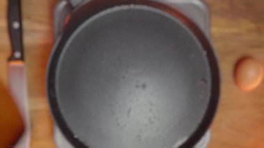 Ahşap bir kaşık, bir tava ve lezzetli tarifler için bir yumurta kullanarak yemek yapmaya hazırlanıyorum.